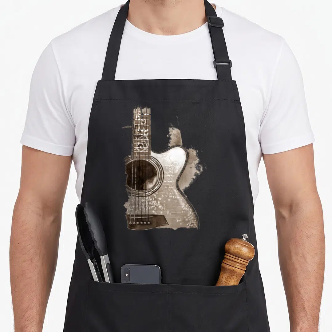 Acoustic book apron - Brown and white watercolor painting of an acoustic guitar with splatter effects — shown on a black cotton canvas apron against a white background