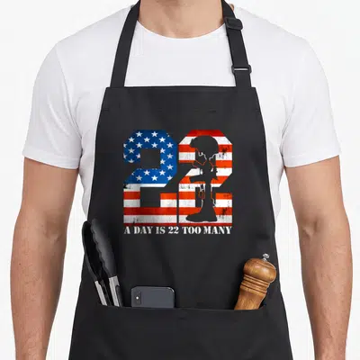 Many female veteran apron - Number 22 filled with distressed US flag and soldier silhouette with text below — shown on a black cotton canvas apron against a white background