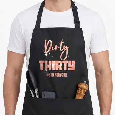 Girly funny dirty aprons - Stacked Dirty THIRTY #BIRTHDAYGIRL text in peach marble with white sparkles and gold veins — shown on a black cotton canvas apron against a white background