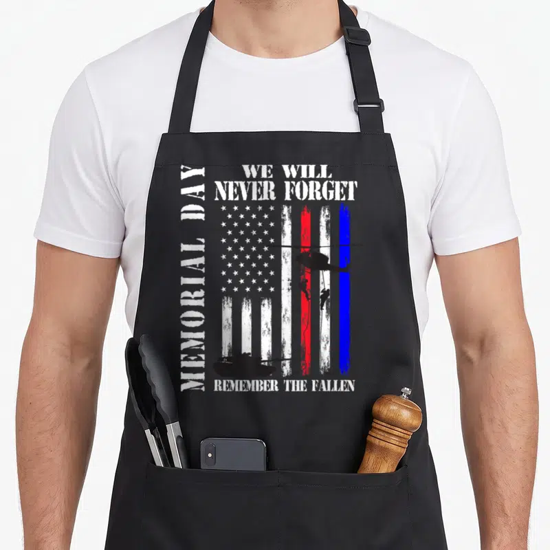 Memorial marine dad apron - Distressed US flag with MEMORIAL DAY text, helicopter, rappelling soldiers, and tank — shown on a black cotton canvas apron against a white background