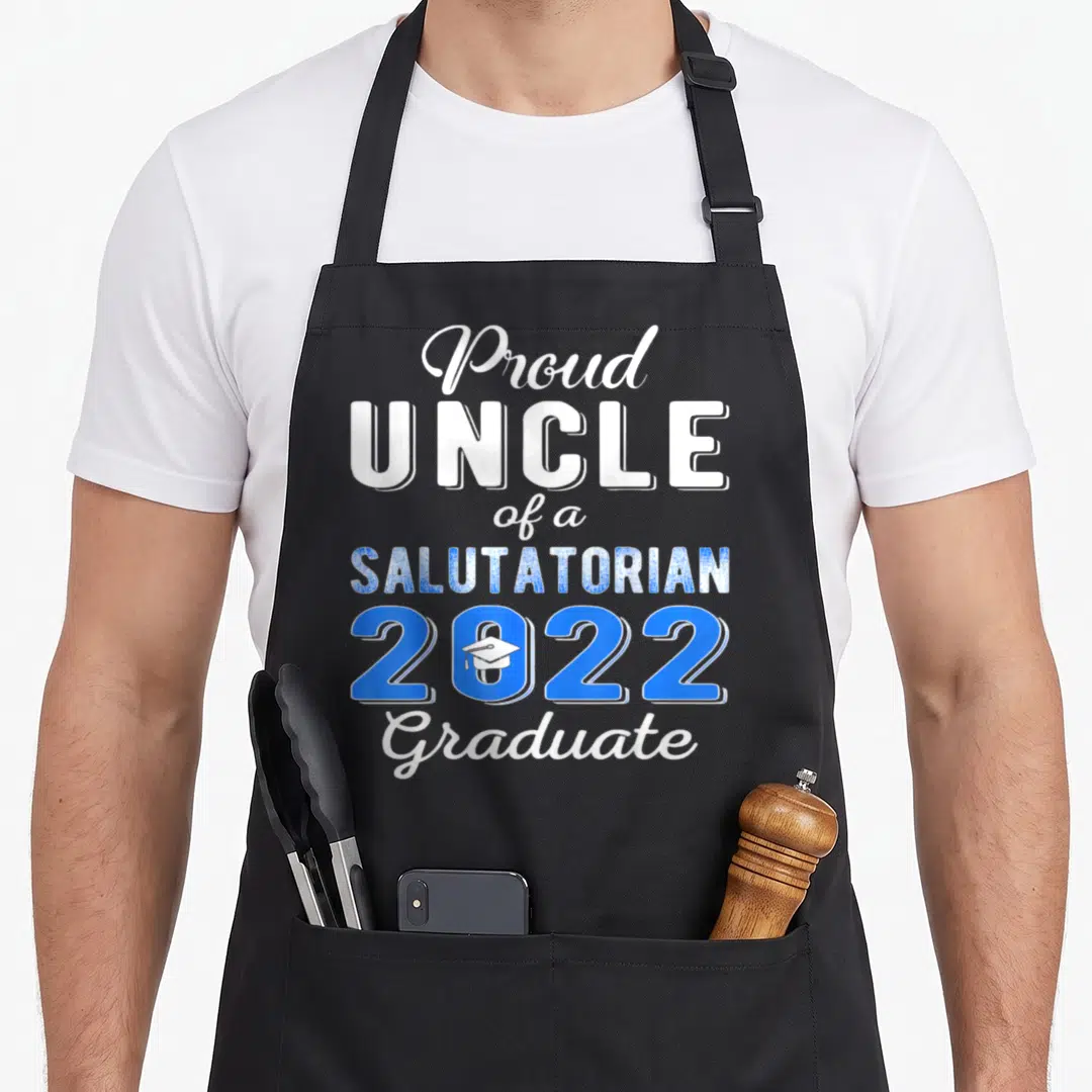 Proud salutatorian life apron - Stacked white and blue text Proud Uncle of a Salutatorian 2022 Graduate with cap icon — shown on a black cotton canvas apron against a white background