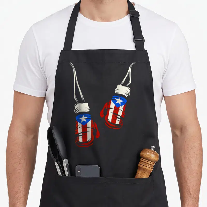 Puerto gloves and apron - Two boxing gloves wrapped in red white and blue flag design hanging by laces — shown on a black cotton canvas apron against a white background