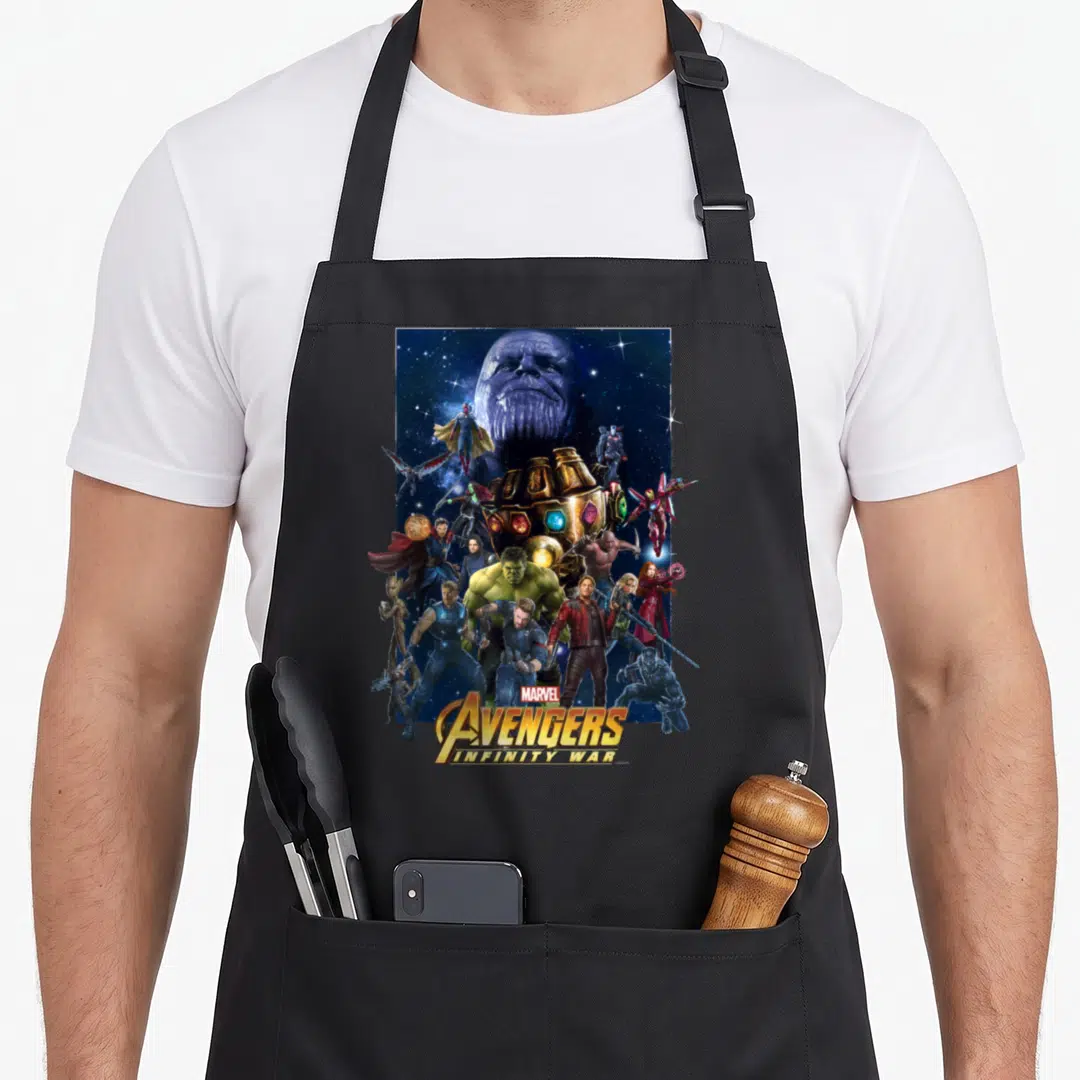 Hero infinity apron - Thanos head and Avengers cluster around Infinity Gauntlet with stacked title text at bottom — shown on a black cotton canvas apron against a white background