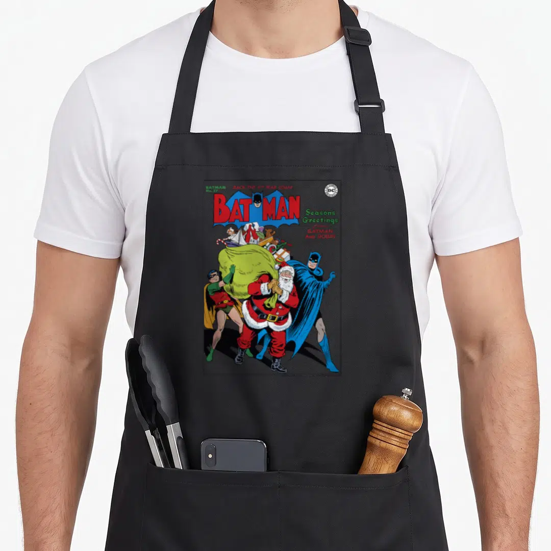 Greeting christmas robin apron - Vintage Batman comic cover with Santa, War Loan text, and cartoon characters in red — shown on a black cotton canvas apron against a white background