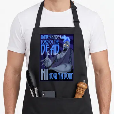 Hercule classical quotes apron - Cartoon Hades with NAME'S HADES LORD OF THE DEAD HI NOW YA DOIN' text on blue purple — shown on a black cotton canvas apron against a white background
