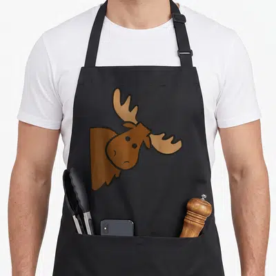 Elk moose apron - Cartoon moose head peeking in brown and tan on black apron — shown on a black cotton canvas apron against a white background