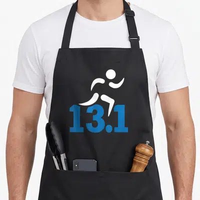 Mile marathon apron - White runner silhouette above blue 13.1 text on black fabric — shown on a black cotton canvas apron against a white background