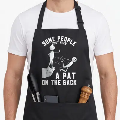 Pat joke apron - White cartoon stick figure pushing another off a cliff with arched text — shown on a black cotton canvas apron against a white background