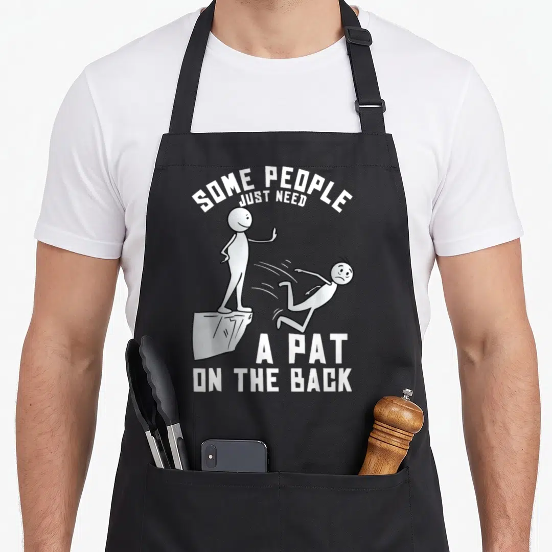Pat joke apron - White cartoon stick figure pushing another off a cliff with arched text — shown on a black cotton canvas apron against a white background