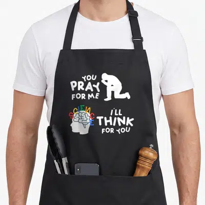 Pray science apron - You Pray For Me Science I'll Think For You with colorful brain and praying figure — shown on a black cotton canvas apron against a white background