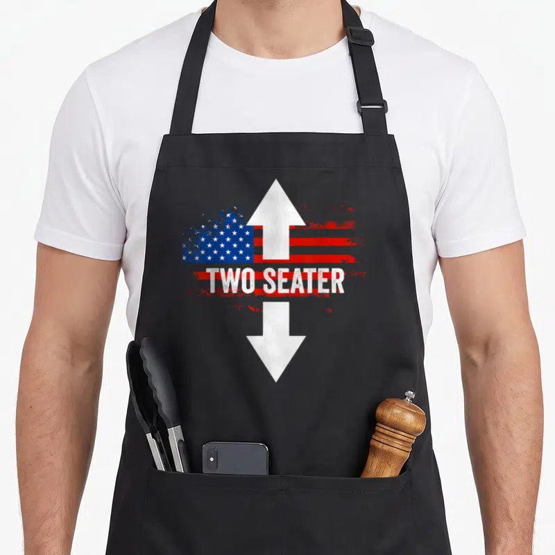 4th the dirty apron - Distressed US flag with white double arrow and white text reading TWO SEATER — shown on a black cotton canvas apron against a white background
