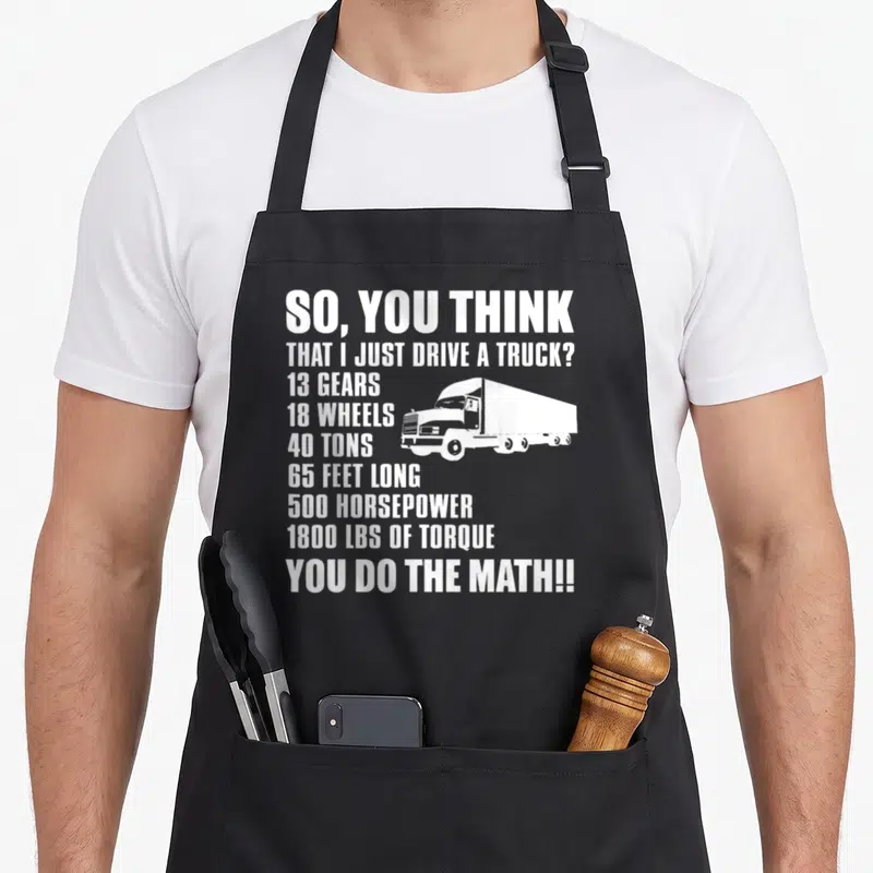 Math truck apron - White stacked text listing truck specs next to a semi-truck silhouette — shown on a black cotton canvas apron against a white background