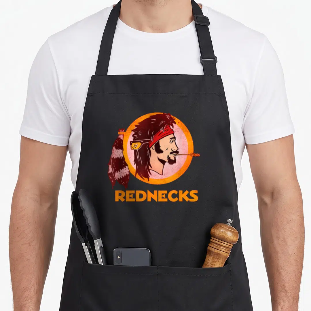 Washington football apron - Cartoon man head in orange circle with feather and REDNECKS text — shown on a black cotton canvas apron against a white background