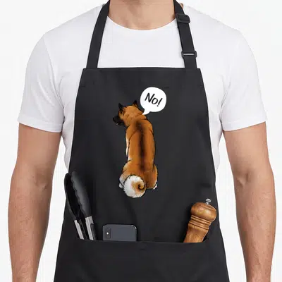 Breeder dog apron - Cartoon brown and white dog facing away with white speech bubble reading No! — shown on a black cotton canvas apron against a white background