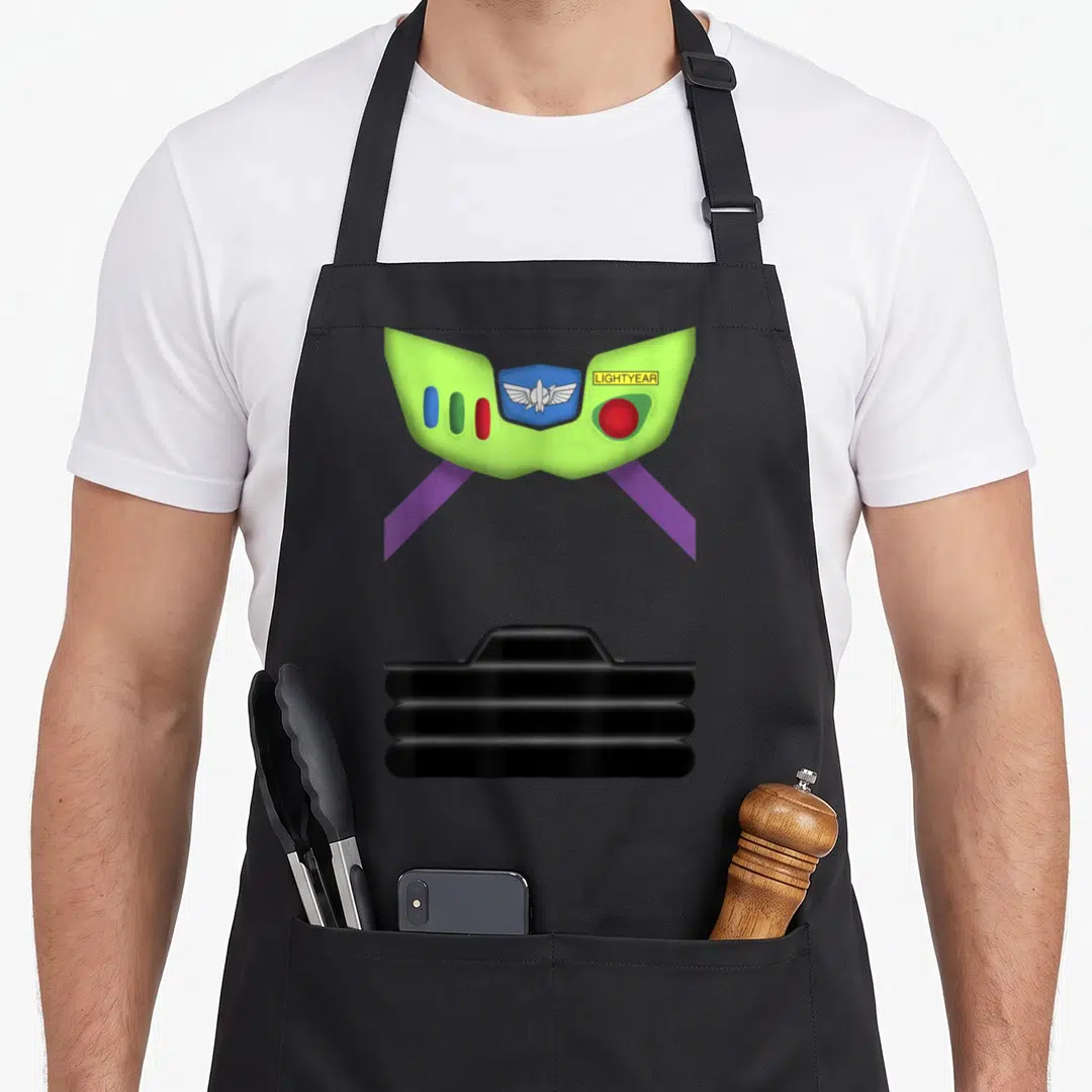 Cute costume halloween apron - Lime green Buzz Lightyear chest plate with wing emblem, colored buttons, purple straps — shown on a black cotton canvas apron against a white background