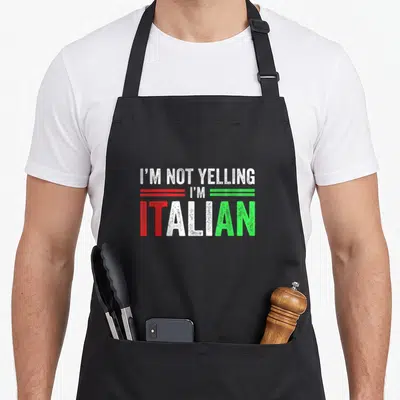 Flag italian apron - Stacked text I'm Not Yelling I'm Italian in red white and green flag colors — shown on a black cotton canvas apron against a white background