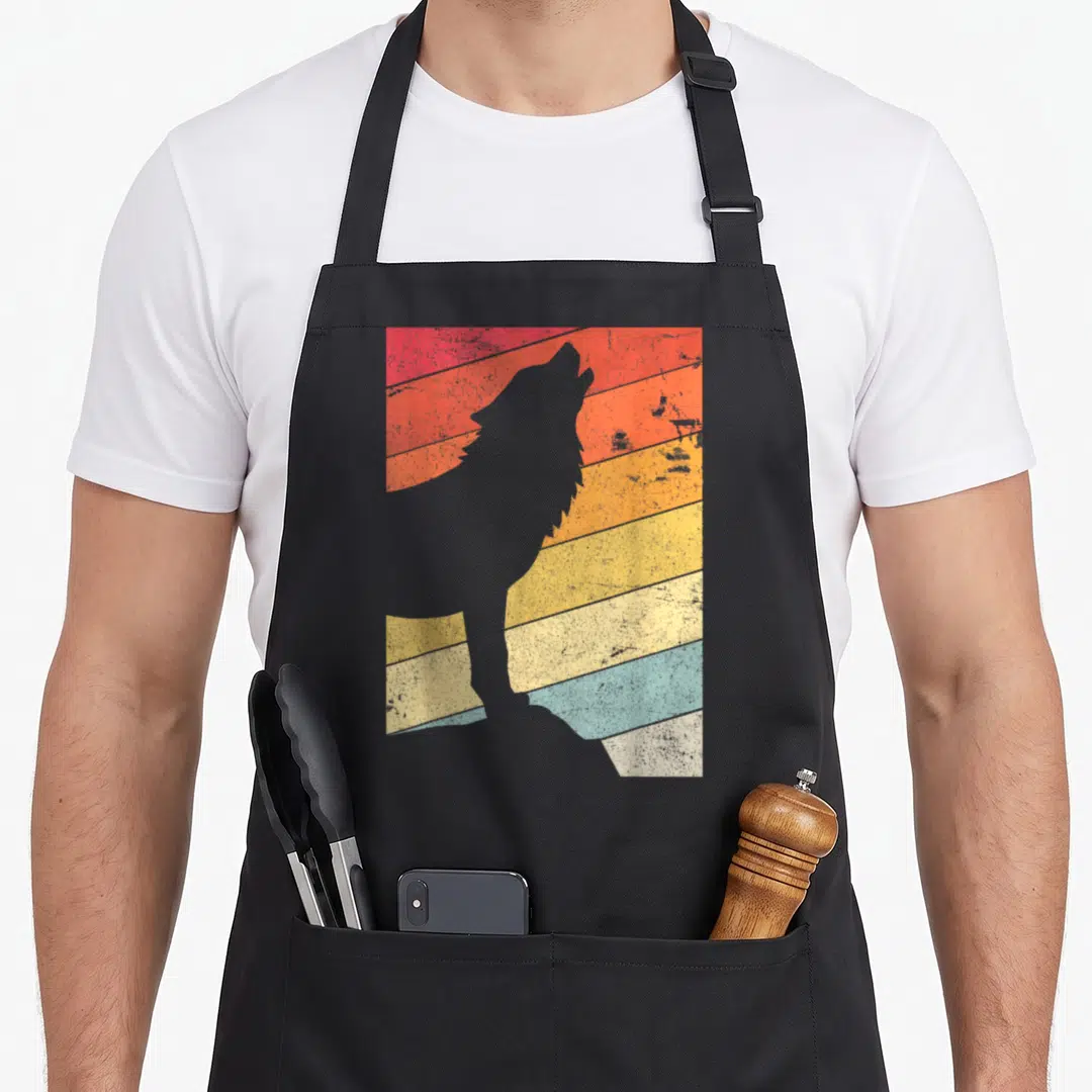 Cute wolf apron - Grey wolf silhouette against horizontal stripes in red, orange, yellow, blue on black bib apron — shown on a black cotton canvas apron against a white background