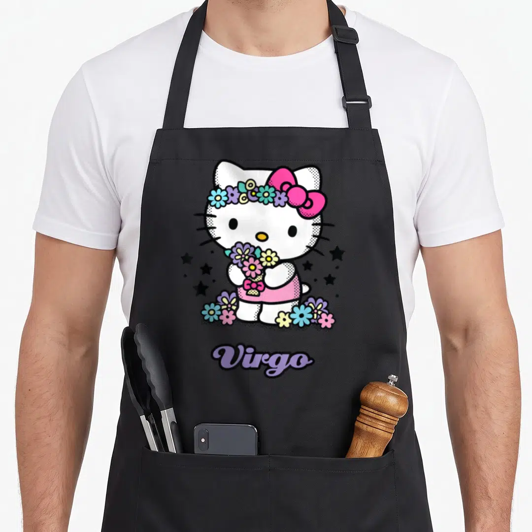 Virgo zodiac aprons - Hello Kitty holding flowers with a crown, black stars, Virgo text below in purple script — shown on a black cotton canvas apron against a white background
