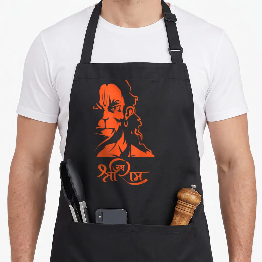 Hanuman ram apron - Orange stylized Hanuman head above Hindi text Jai Shri Ram — shown on a black cotton canvas apron against a white background