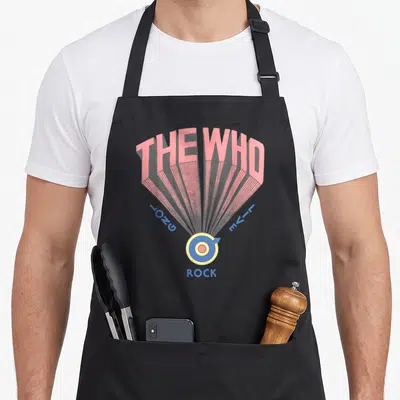 Live rock apron - Pink radiating lines connect THE WHO text to a blue and yellow target symbol with ROCK below — shown on a black cotton canvas apron against a white background