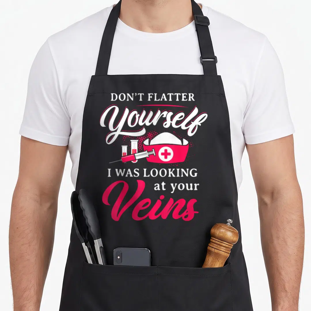 Technician phlebotomist nurse apron - DON'T FLATTER Yourself I WAS LOOKING at your Veins text with nurse hat syringe — shown on a black cotton canvas apron against a white background