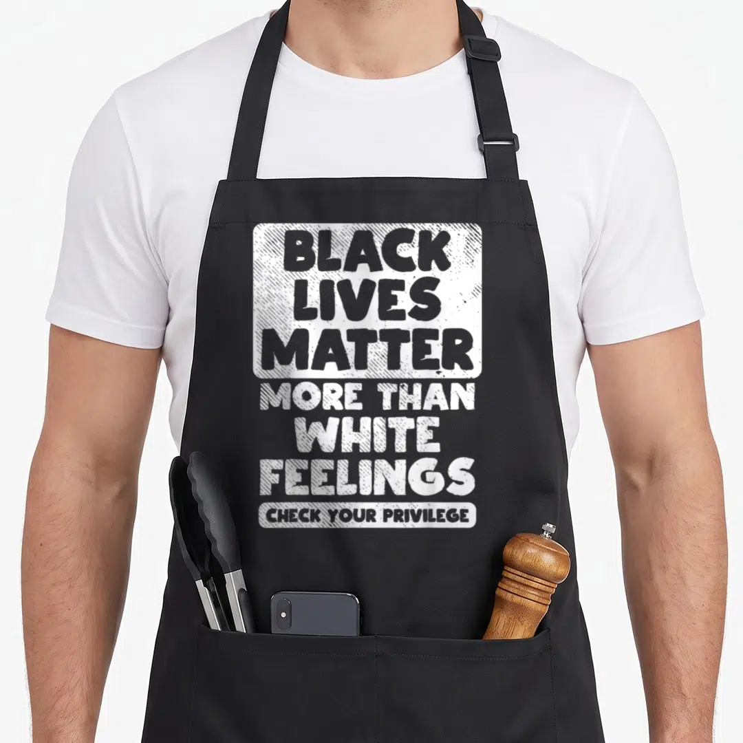 Live african apron - White stacked text reading Black Lives Matter More Than White Feelings Check Your Privilege — shown on a black cotton canvas apron against a white background