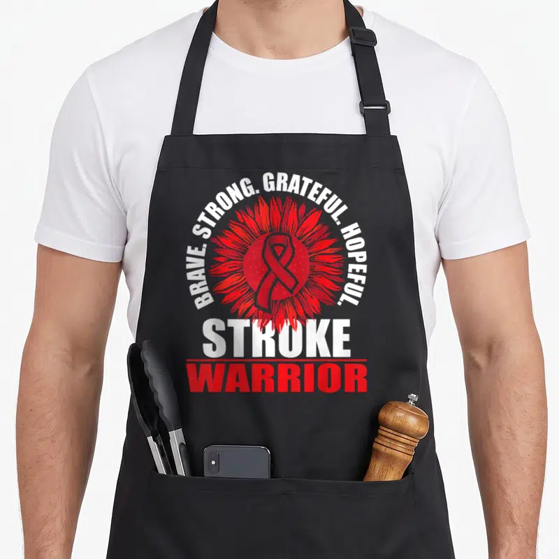 Stroke warrior ribbon apron - Red sunflower with awareness ribbon and text Brave Strong Grateful Hopeful Stroke Warrior — shown on a black cotton canvas apron against a white background