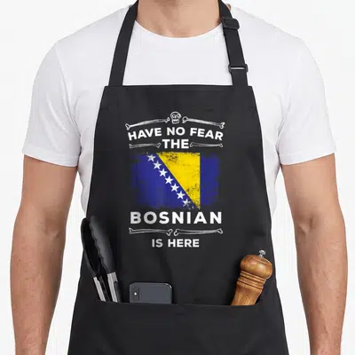 Bosnian bosnia and herzegovina apron - Distressed Bosnia flag with skull bones and HAVE NO FEAR text — shown on a black cotton canvas apron against a white background