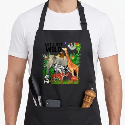 Wildlife safari birthday apron - Cartoon elephant giraffe zebra and lion under LETS GET WILD text surrounded — shown on a black cotton canvas apron against a white background
