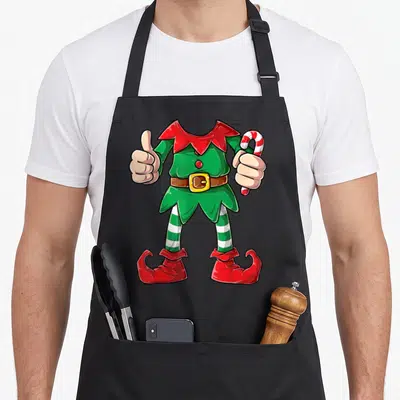 Elve christmas elf apron - Cartoon headless elf outfit giving thumbs up holding candy cane in green red and white — shown on a black cotton canvas apron against a white background