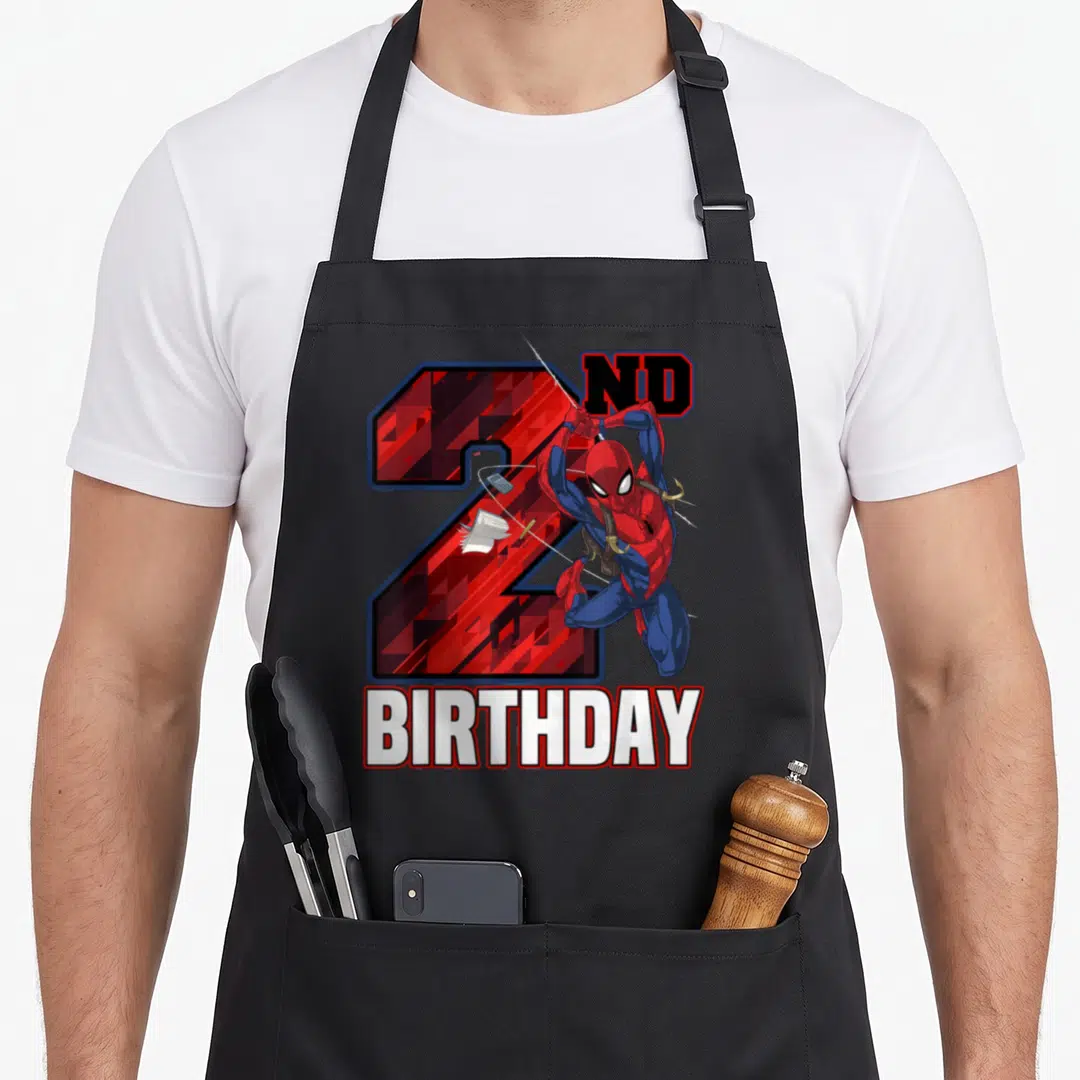 Web 2nd apron - Superhero leaping over red number 2 with ND BIRTHDAY text — shown on a black cotton canvas apron against a white background
