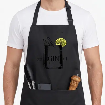 Original gin apron - Line art cocktail glass with two straws, yellow lemon slice, and ori GIN al text — shown on a black cotton canvas apron against a white background