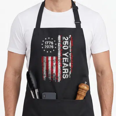 Anniversary patriotic usa apron - Vertical distressed USA flag with 1776 2026 dates and 250 YEARS text — shown on a black cotton canvas apron against a white background
