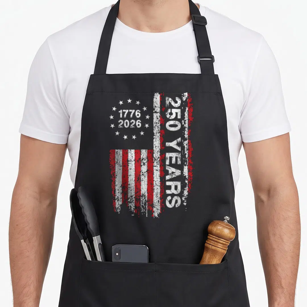 Anniversary patriotic usa apron - Vertical distressed USA flag with 1776 2026 dates and 250 YEARS text — shown on a black cotton canvas apron against a white background