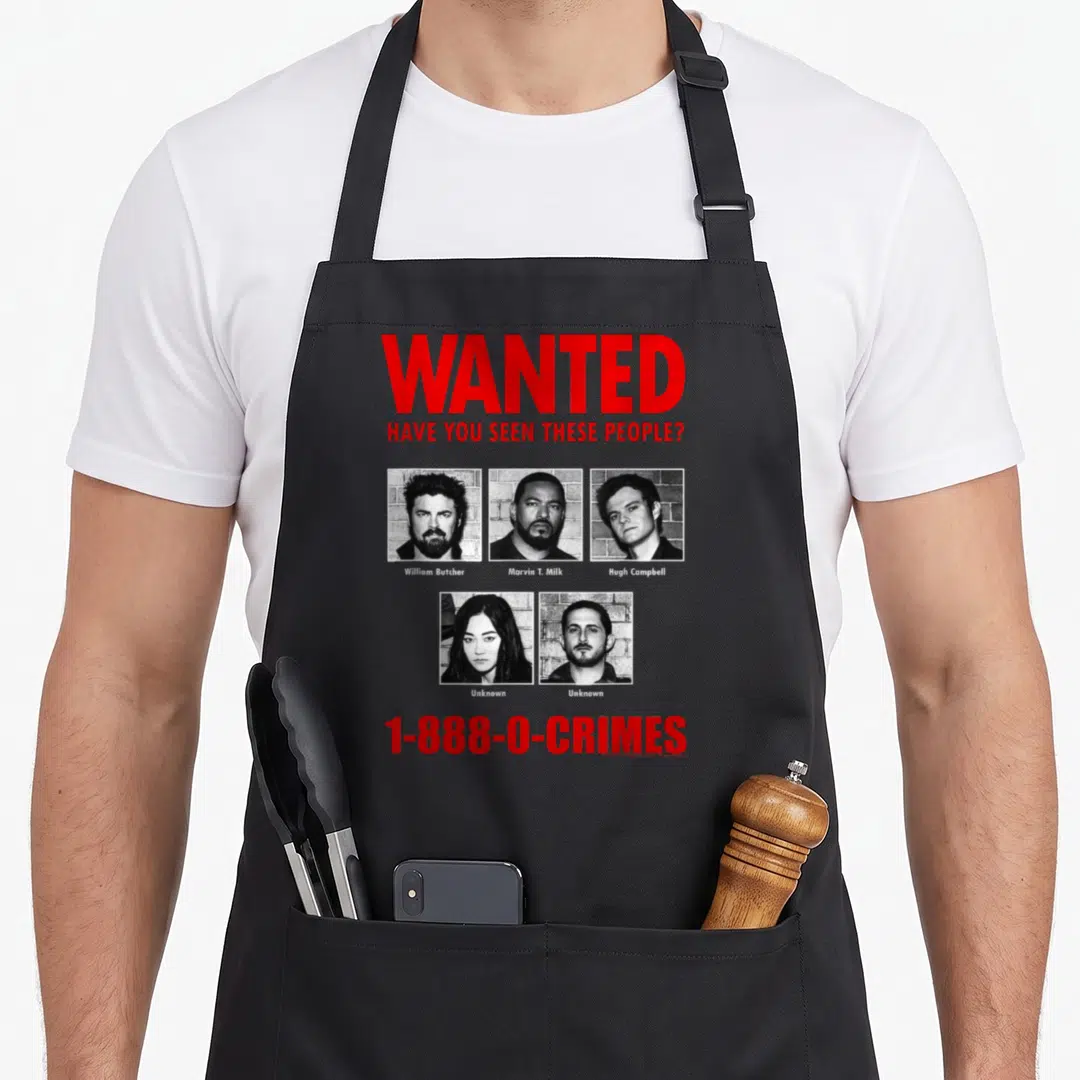 Anti superhero apron - Wanted poster with five portraits and red text reading WANTED HAVE YOU SEEN THESE PEOPLE on gray — shown on a black cotton canvas apron against a white background