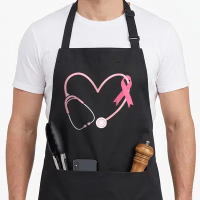 Doctor ribbon apron - Stethoscope heart shape with pink ribbon overlap, minimalist pink and white design — shown on a black cotton canvas apron against a white background