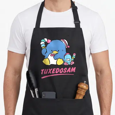 Tuxedosam ice cream apron - Two blue penguins holding ice cream with pink TUXEDOSAM text below — shown on a black cotton canvas apron against a white background