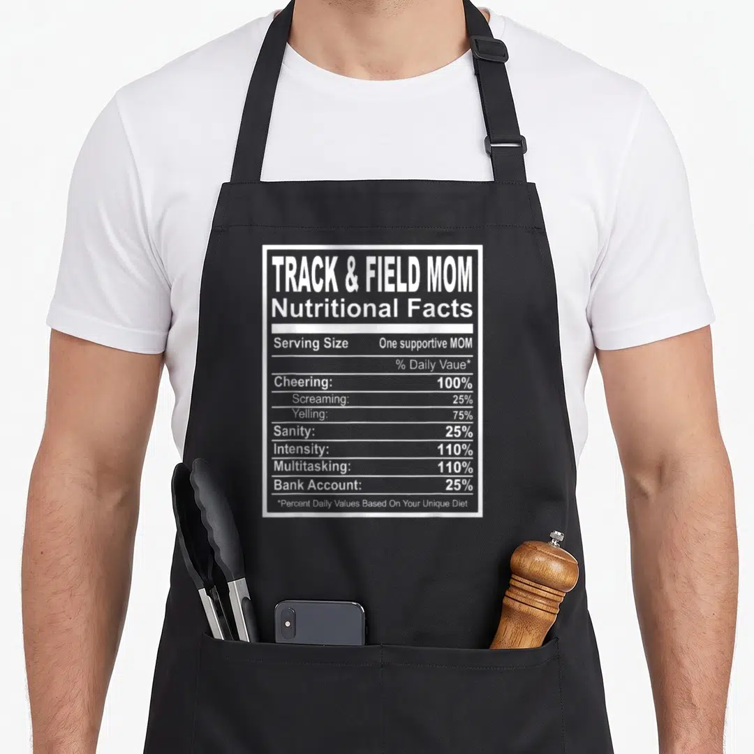 Nutrition track apron - White nutrition facts label print listing Cheering at 100 percent and Sanity at 25 percent — shown on a black cotton canvas apron against a white background