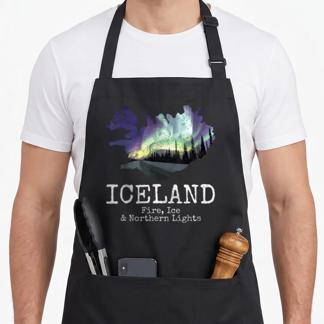 Fire icelandic apron - Distressed Iceland map with aurora borealis and stacked white text reading Fire Ice Northern — shown on a black cotton canvas apron against a white background