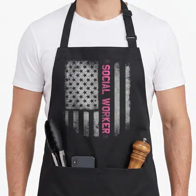 Social us aprons - Distressed grey US flag with vertical pink SOCIAL WORKER text — shown on a black cotton canvas apron against a white background