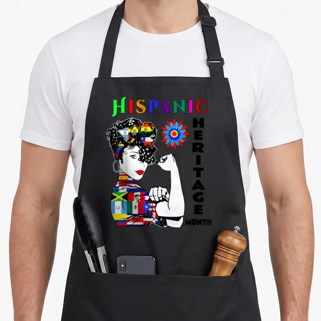 Month country apron - Cartoon woman made of flags flexing arm next to stacked HISPANIC HERITAGE MONTH text — shown on a black cotton canvas apron against a white background