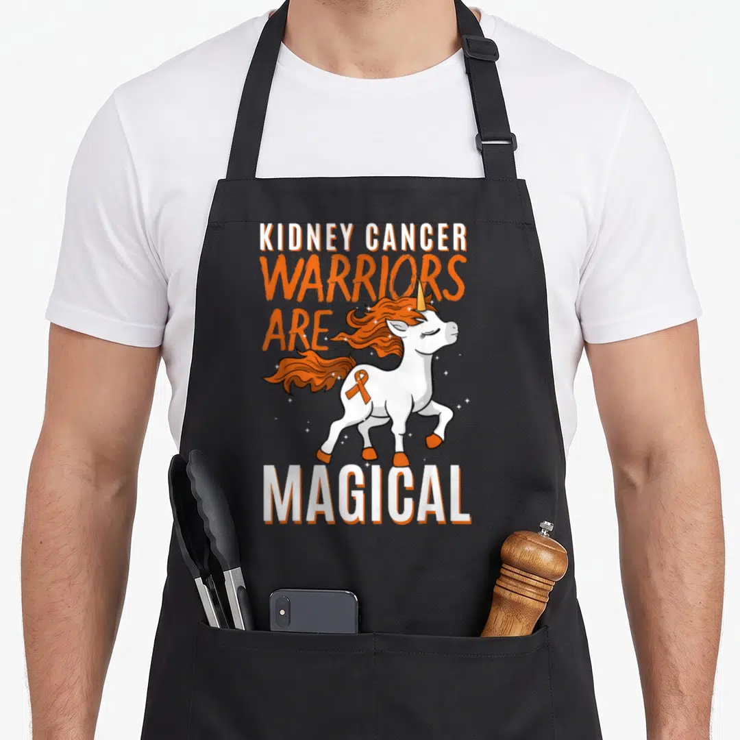 Cancer unicorn apron - Cartoon unicorn with orange ribbon and KIDNEY CANCER WARRIORS ARE MAGICAL text — shown on a black cotton canvas apron against a white background