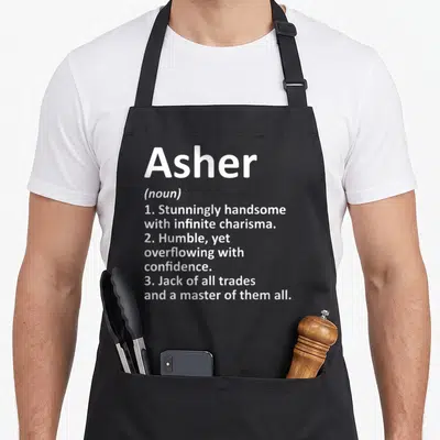 Asher father day aprons - White text defining Asher as handsome, humble, and a master of all trades stacked vertically — shown on a black cotton canvas apron against a white background