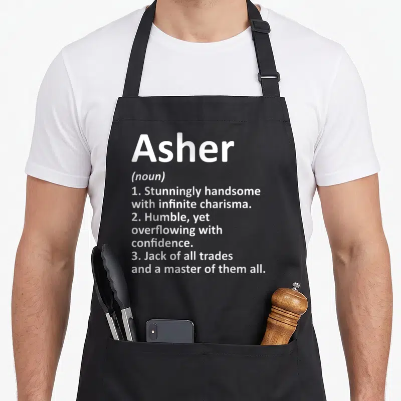 Asher father day aprons - White text defining Asher as handsome, humble, and a master of all trades stacked vertically — shown on a black cotton canvas apron against a white background