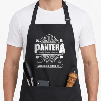 Pantera st patrick day aprons - White distressed Pantera emblem with four clovers and Stronger Than All text — shown on a black cotton canvas apron against a white background