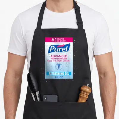 Sanitizer halloween apron - Purell brand label print with caduceus symbol and water droplets in blue and magenta — shown on a black cotton canvas apron against a white background