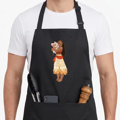 Funny pua novelty apron - Cartoon woman standing hugging a white pig wearing a red top and patterned cream skirt — shown on a black cotton canvas apron against a white background