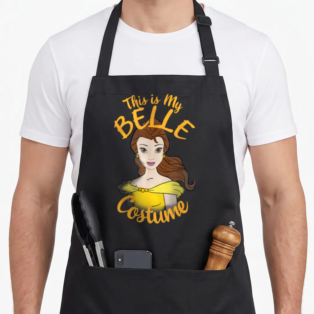 Belle halloween apron - Cartoon Belle in yellow dress with This is My BELLE Costume text in orange and brown — shown on a black cotton canvas apron against a white background