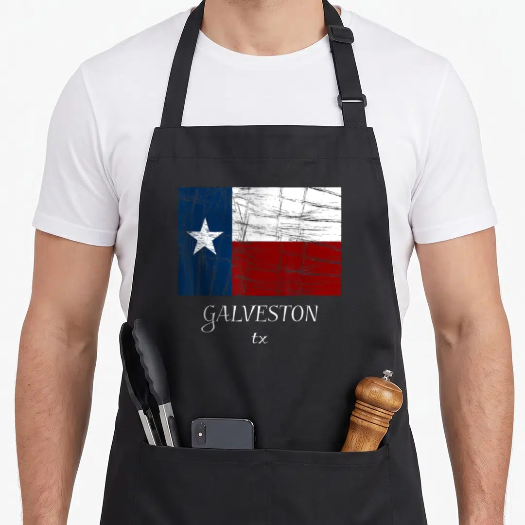 Galveston texas flag apron - Distressed Texas flag in blue white red above GALVESTON tx text — shown on a black cotton canvas apron against a white background