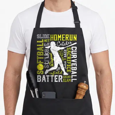 Softball pitcher apron - White and yellow softball words surrounding a batter silhouette with a yellow ball at bottom — shown on a black cotton canvas apron against a white background